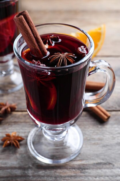 Delicious red mulled wine on wooden table closeup