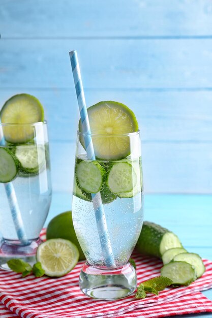 Delicious refreshing water with mint and cucumber in glass on table