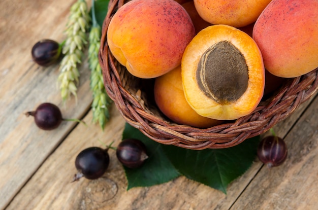 Delicious ripe apricots and berries on rustic background. Healthy foods. 