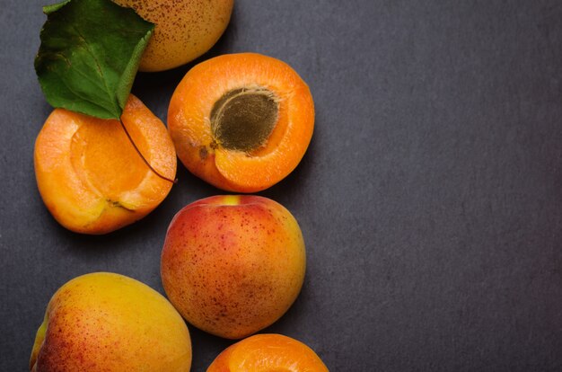 Delicious ripe apricots on black shale background