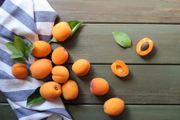 Delicious ripe apricots in a wooden bowl on the table closeup Flat lay concept