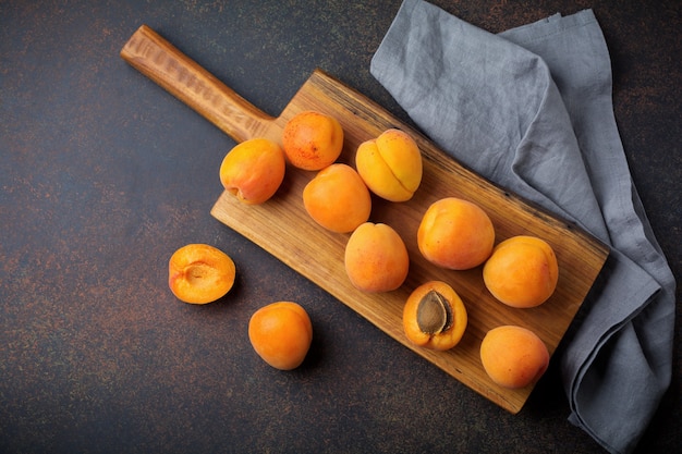 Delicious ripe apricots on a wooden stand