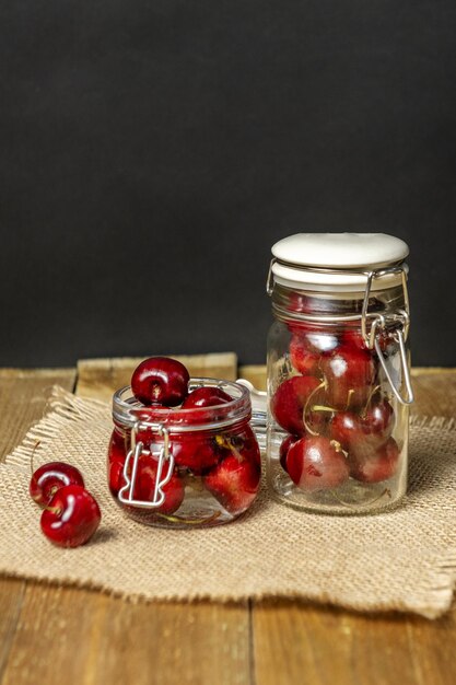 Photo delicious ripe cherries inside glass jars