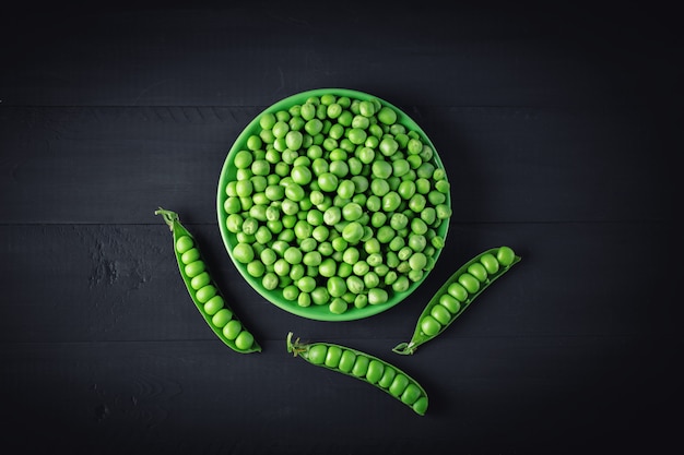 Delicious ripe green peas lying on a wooden table