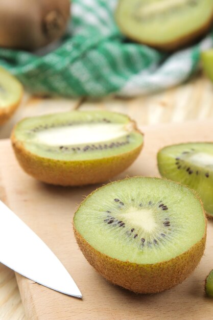 Delicious ripe lots of kiwi fruit and kiwi cutaway cut on a natural wooden table closeup