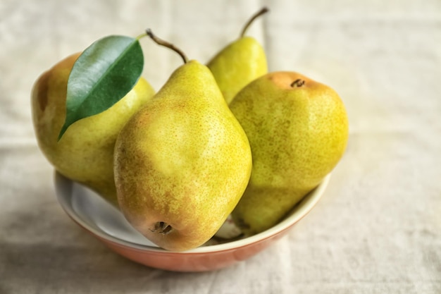 Foto deliziose pere mature in una ciotola sul tavolo