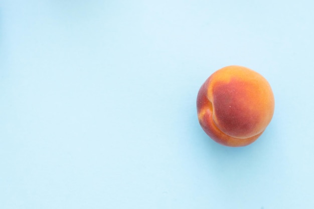 Delicious ripe sweet apricots on blue background flat lay Space for text