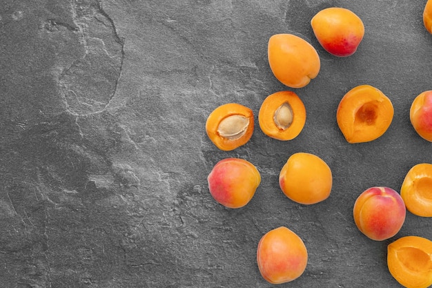 Delicious ripe sweet apricots on dark background top view Space for text