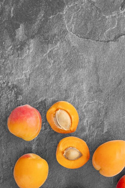 Delicious ripe sweet apricots on dark background top view Space for text