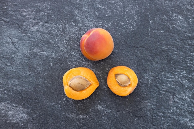 Delicious ripe sweet apricots on dark background top view Space for text