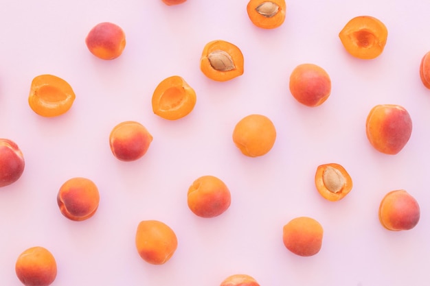 Delicious ripe sweet apricots on pink background flat lay