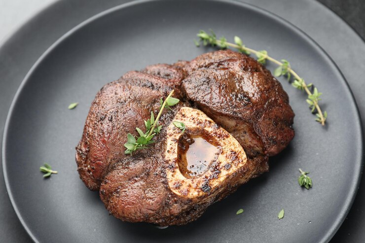 Photo delicious roasted beef meat with thyme on plate closeup