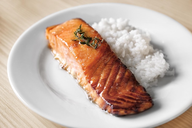 Delicious roasted salmon fillet with rice on white plate