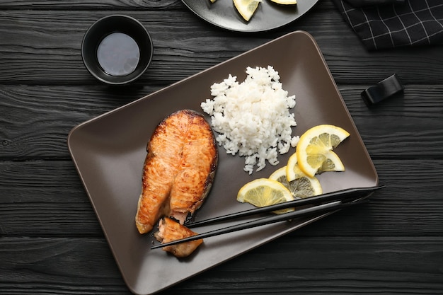 おいしいロースト サーモン ステーキとご飯を皿にのせて