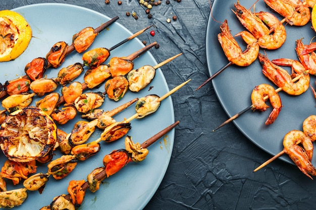 Photo delicious roasted shrimps and mussels on wooden skewers