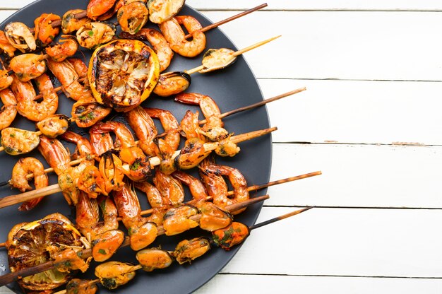 Delicious roasted shrimps and mussels on wooden skewers