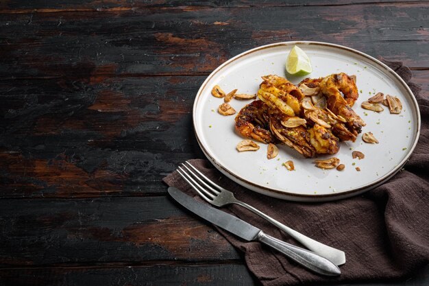 Delicious roasted shrimps with garlic, curry and mango sauce set, on plate, on old dark  wooden table