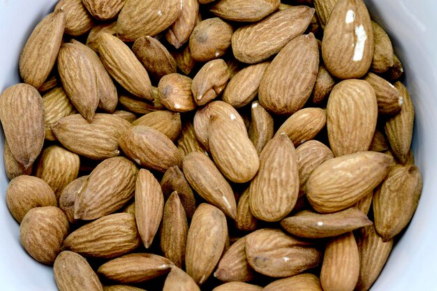 Delicious roasted sweet almonds lie in a white bowl