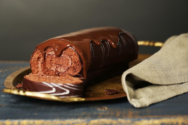 Foto delizioso roll cake su un tavolo di legno su uno sfondo scuro