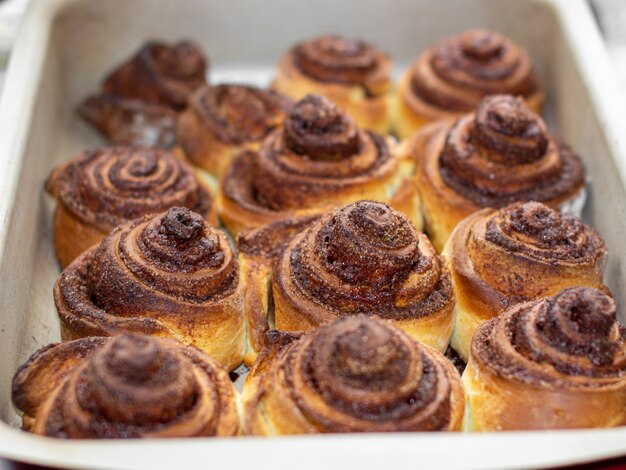 Delicious round cinnamon rolls on a baking sheet after the oven. I cook buns at home in the oven.