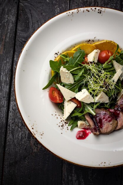 delicious salad in a plate on a dark table