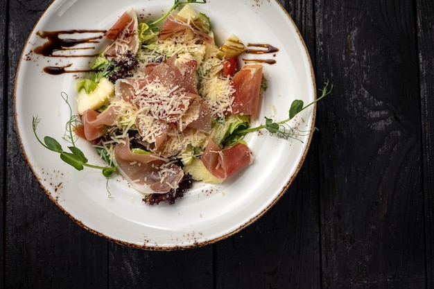 delicious salad in a plate on a dark table