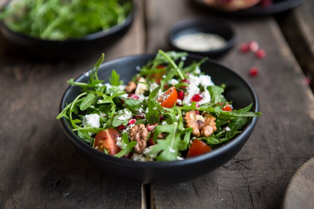 Delicious salad with  arugula and goat cheese on white plate, top view, copy space