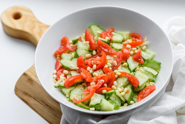 A delicious salad with beans tomatoes and cucumbers on a white background Making a delicious healthy breakfast