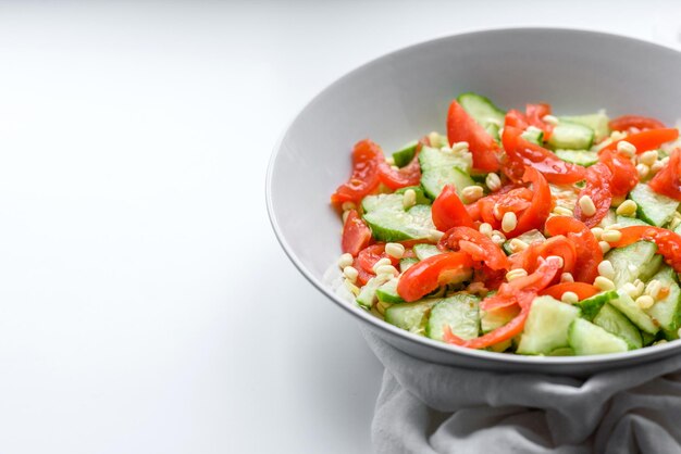 A delicious salad with beans tomatoes and cucumbers on a white background Making a delicious healthy breakfast