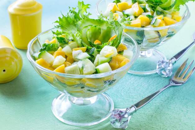 Delicious salad with cucumber and mango in glass vases