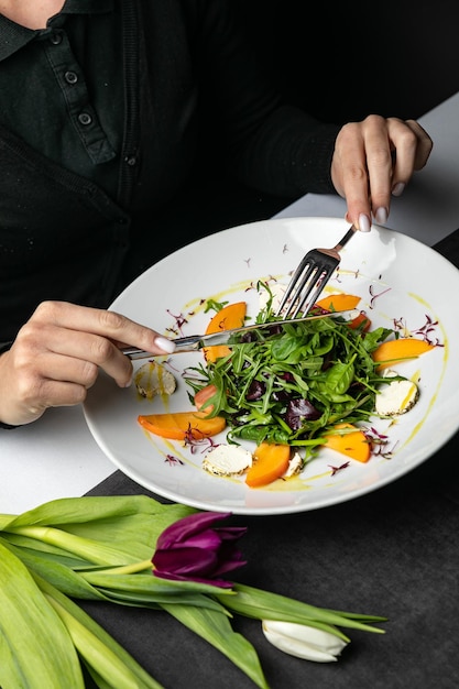 Delicious salad with figs arugula and goat cheese on white plate top view