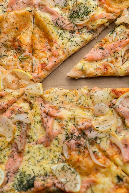 Delicious salmon pizza in a cardboard box