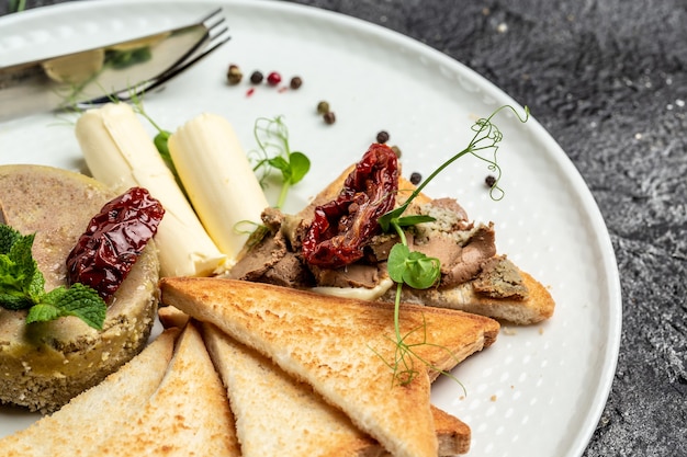 Delicious sandwich made of pate with butter and sun-dried tomatoes and bread. Fresh homemade chicken liver pate