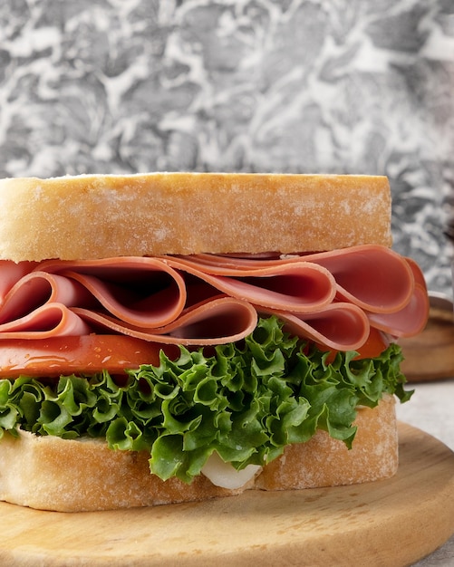 Delicious sandwich of mortadella, lettuce, cheese and tomato. Selective focus.