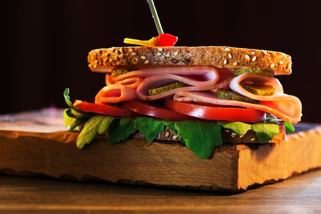 Delicious sandwich with ham, tomato, arugula