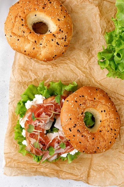 Foto delizioso panino con crema di prosciutto e microgreens per colazione bagel con prosciutto