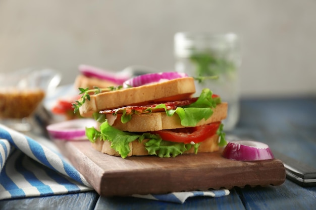 Delicious sandwich on wooden board closeup