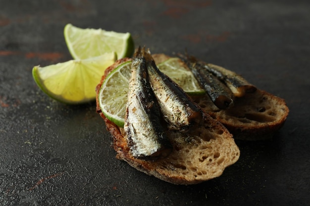 Delicious sandwiches with sprats on textured background