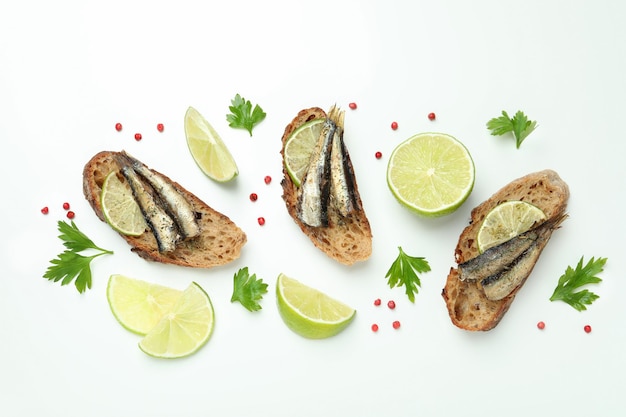 Delicious sandwiches with sprats on white background