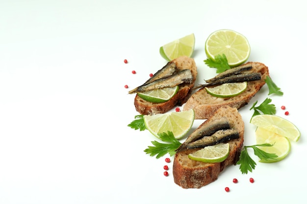 Delicious sandwiches with sprats on white background