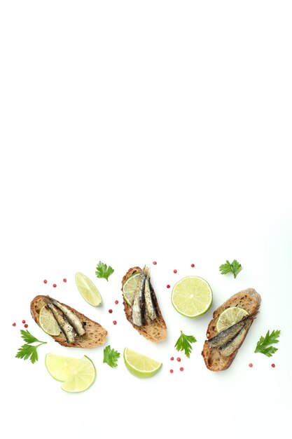 Delicious sandwiches with sprats on white background