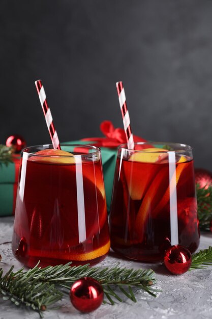 Delicious Sangria drankje in glazen en kerstversieringen op grijze textuur tafel close-up