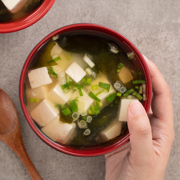 Delicious savory Japanese miso soup in a black bowl for eating