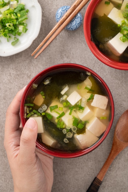 Delicious savory Japanese miso soup in a black bowl for eating