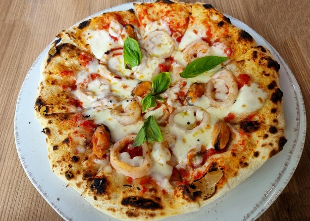 Delicious seafood cocktail pizza on a wooden table