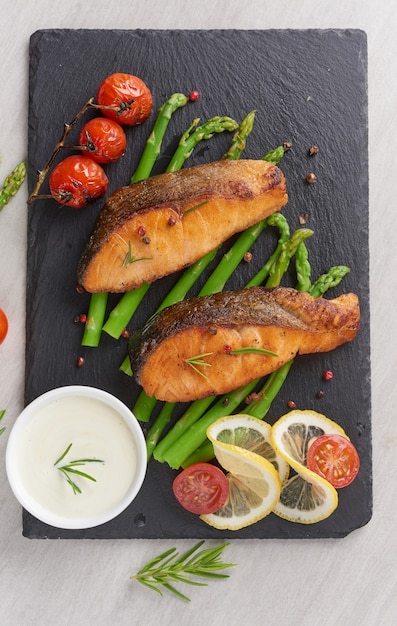 Delicious seasonal green asparagus and sliced smoked salmon on a rustic plate