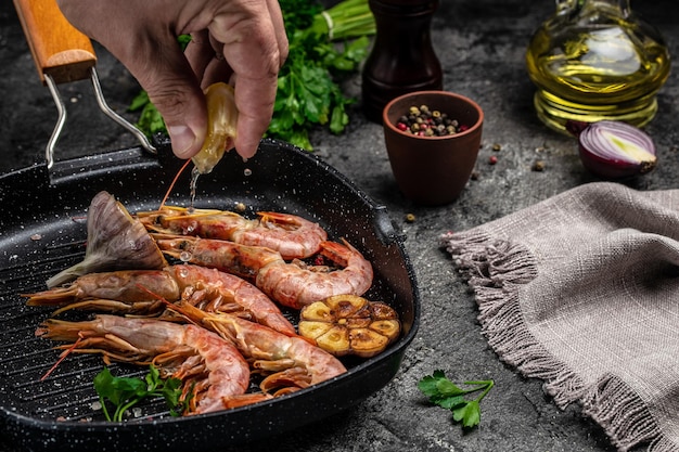 Delicious shrimp with seasoning prawns fried with splashes of lemon juice in a freeze motion on a dark background seafood appetizer culinary cooking concept