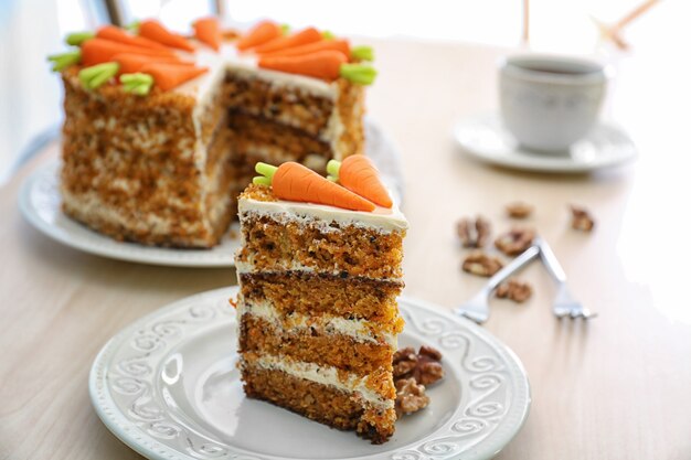 Delicious sliced carrot cake on table