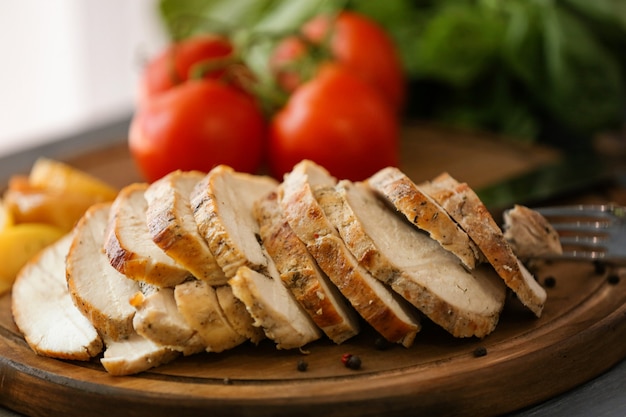 Delicious sliced turkey breast on wooden board