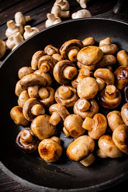 Delicious small fried mushrooms in a frying pan